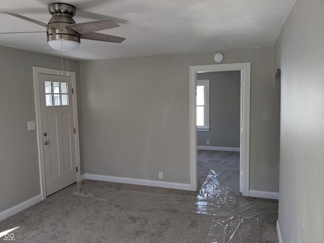 entrance foyer with carpet flooring, a ceiling fan, and baseboards