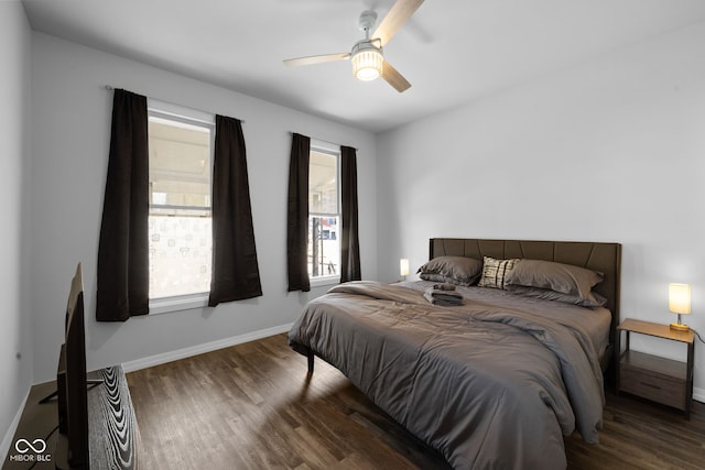 bedroom with a ceiling fan, wood finished floors, and baseboards