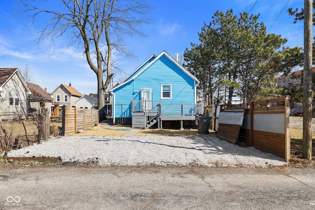 rear view of house with a deck and fence