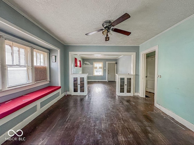 unfurnished living room with ornamental molding, a textured ceiling, baseboards, and wood finished floors