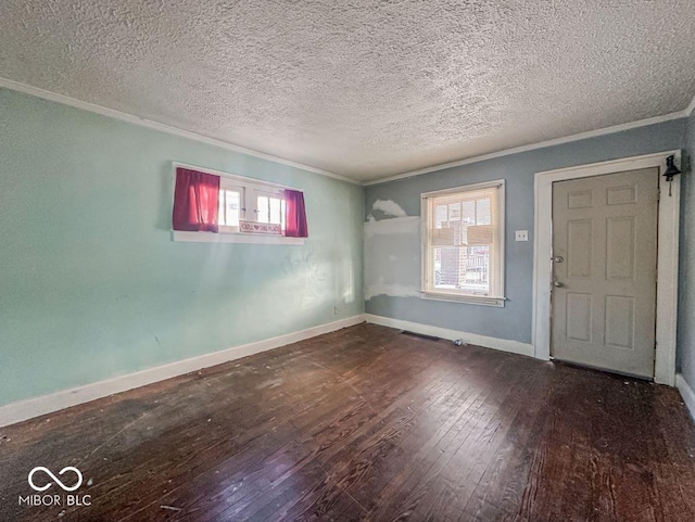 foyer featuring baseboards, wood-type flooring, a textured ceiling, and ornamental molding