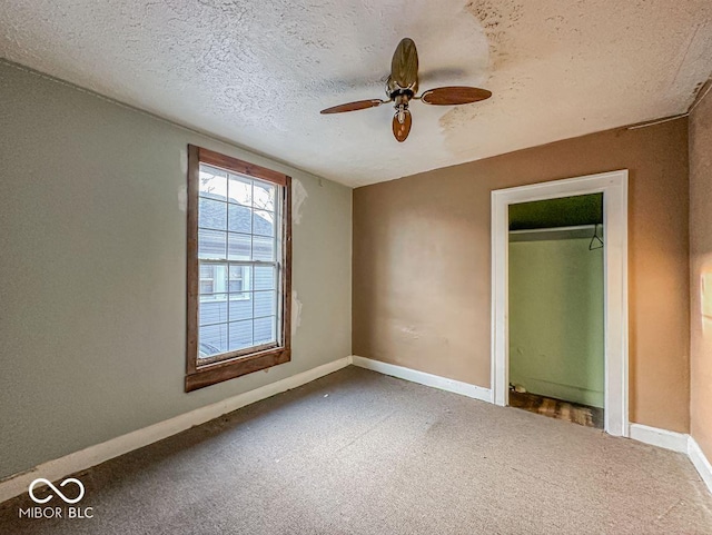 unfurnished bedroom featuring baseboards, a textured ceiling, ceiling fan, and carpet flooring