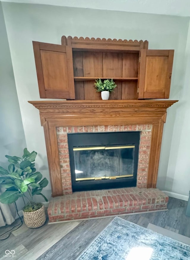 details with a brick fireplace, baseboards, and wood finished floors