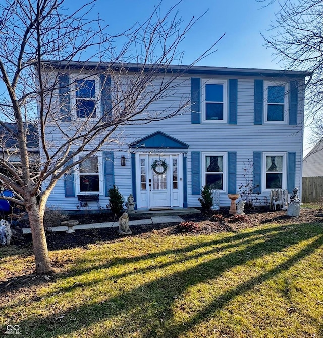 colonial-style house with a front yard and fence