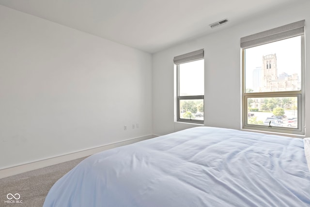 bedroom with visible vents and carpet