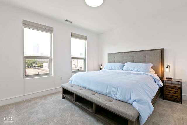 carpeted bedroom featuring visible vents