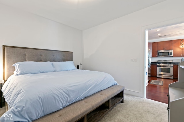 bedroom with baseboards, dark colored carpet, and freestanding refrigerator