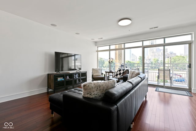 living room featuring visible vents, baseboards, and dark wood finished floors