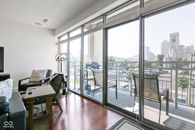 office with a city view, dark wood-type flooring, plenty of natural light, and visible vents