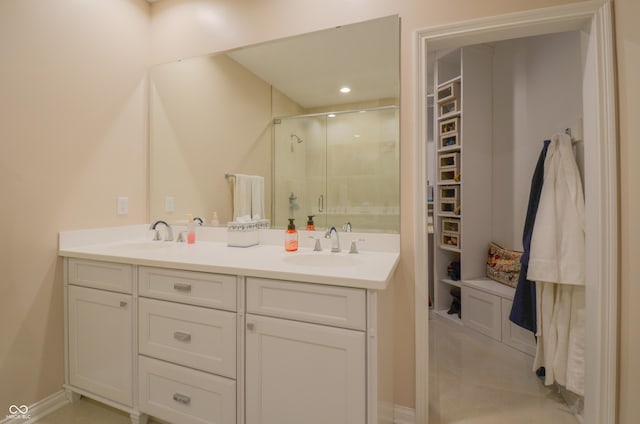 bathroom featuring double vanity, a sink, and a shower stall