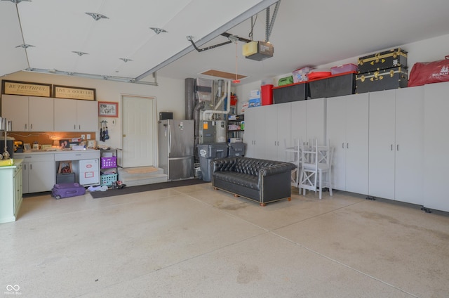 garage with a garage door opener and freestanding refrigerator