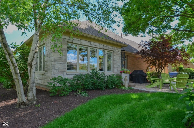 view of side of property featuring stone siding and a shingled roof