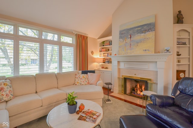 living area with built in features, a fireplace with flush hearth, and vaulted ceiling