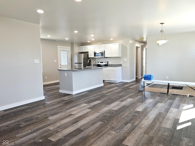 kitchen featuring appliances with stainless steel finishes, white cabinetry, baseboards, and dark wood-style flooring