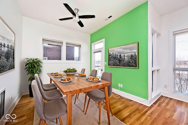 dining area with visible vents, baseboards, light wood-style floors, and a ceiling fan