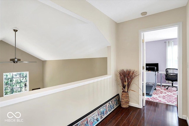 hall featuring baseboards, lofted ceiling, a healthy amount of sunlight, and dark wood-style flooring