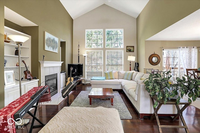 living room featuring dark wood finished floors, a fireplace, and high vaulted ceiling