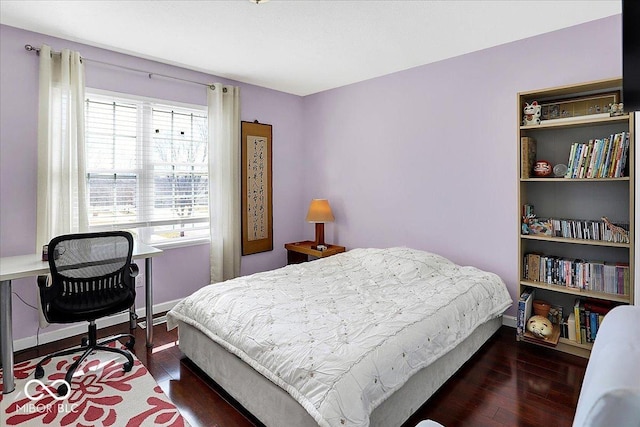 bedroom with baseboards and wood finished floors