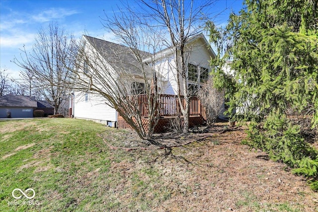 view of side of home featuring crawl space, a lawn, and a wooden deck