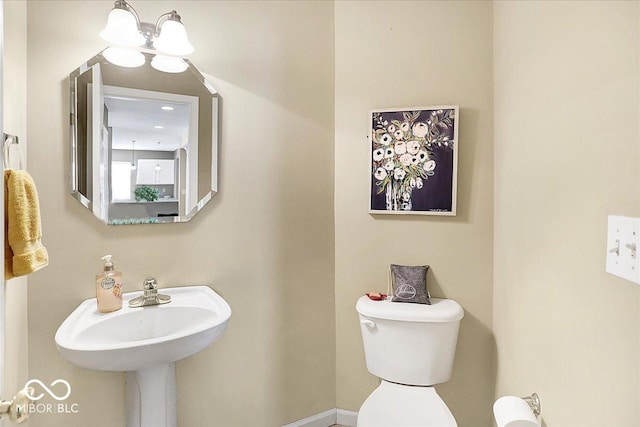 half bathroom with toilet and an inviting chandelier