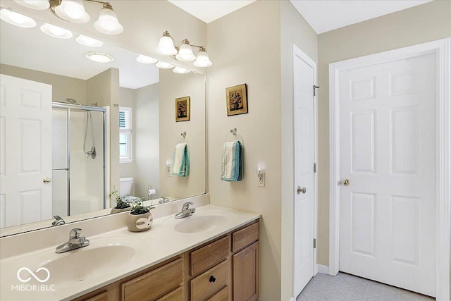 full bath with double vanity, a stall shower, toilet, and a sink