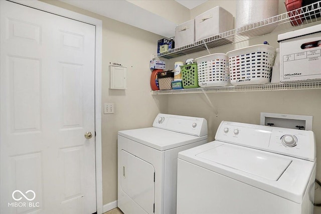 laundry area with laundry area, baseboards, and washing machine and clothes dryer