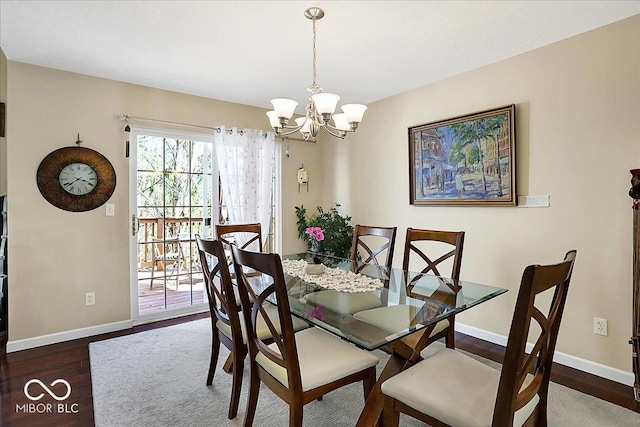 dining room featuring baseboards, an inviting chandelier, and wood finished floors