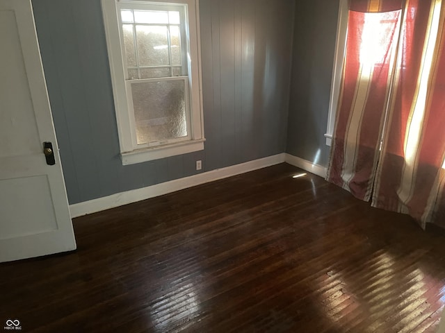 unfurnished room with dark wood-style floors and baseboards