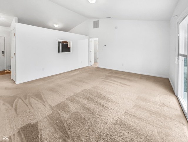 unfurnished room featuring visible vents, light carpet, baseboards, and vaulted ceiling