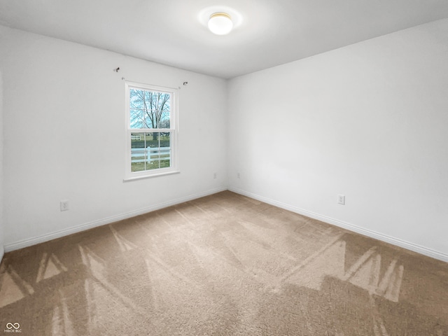 empty room featuring carpet flooring and baseboards