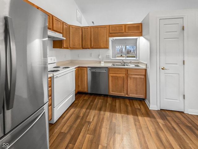 kitchen with under cabinet range hood, appliances with stainless steel finishes, light countertops, and a sink