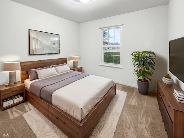 bedroom with light colored carpet and baseboards