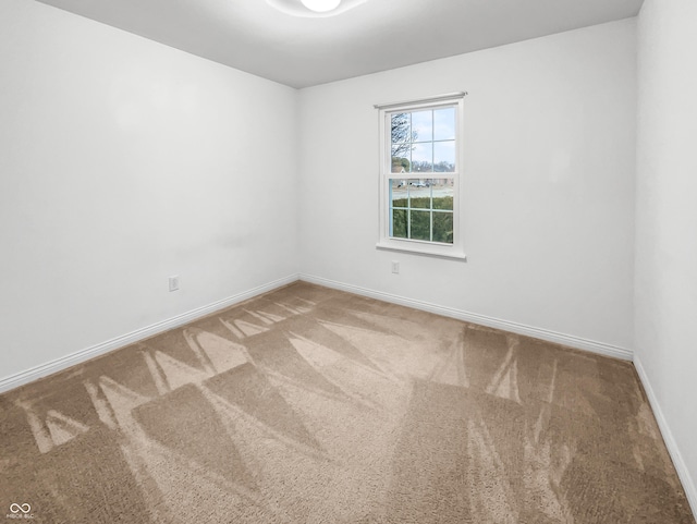 unfurnished room featuring carpet flooring and baseboards