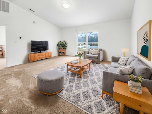 living room with visible vents, baseboards, light colored carpet, and vaulted ceiling