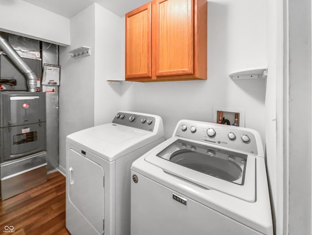 laundry area with cabinet space, independent washer and dryer, and dark wood finished floors