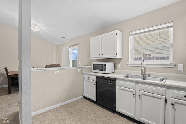 kitchen with a sink, white cabinets, light countertops, white microwave, and dishwasher