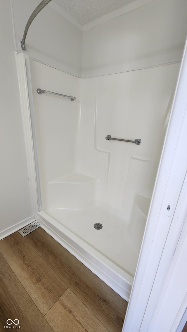 bathroom featuring a shower, a textured ceiling, and wood finished floors