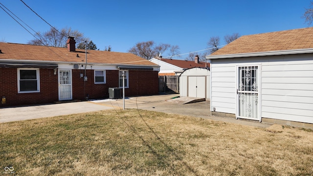 view of yard featuring a patio area, a shed, an outdoor structure, and fence