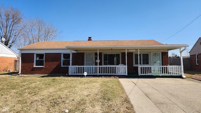 view of front of home featuring a porch, brick siding, and a front lawn