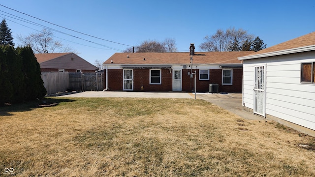 back of property with brick siding, fence, cooling unit, a yard, and a patio