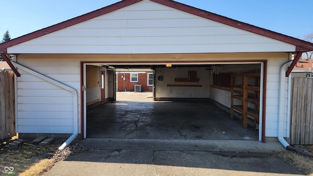 detached garage featuring cooling unit and fence