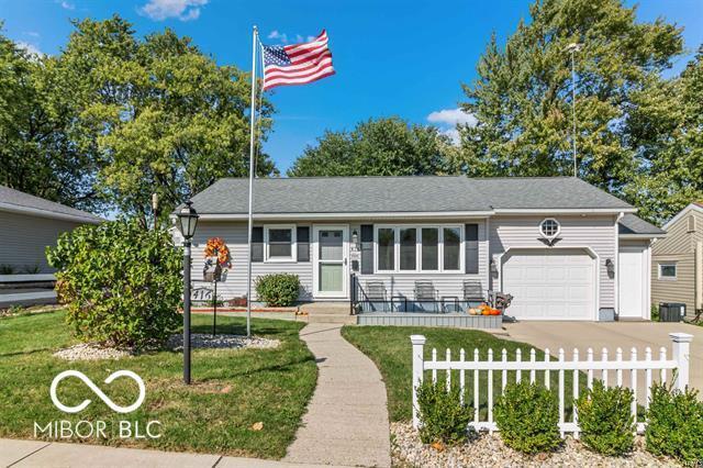 ranch-style home with a fenced front yard, concrete driveway, a garage, and a front yard