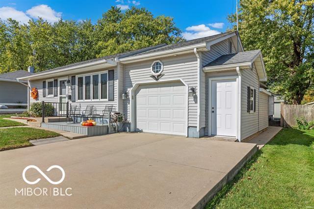 single story home with an attached garage, driveway, a front yard, and fence