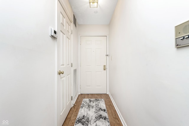 entryway featuring a textured ceiling, baseboards, and light wood-style floors