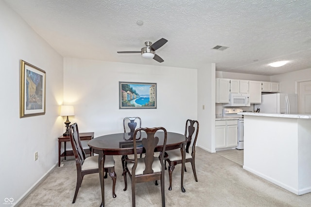 dining area with ceiling fan, baseboards, visible vents, and light carpet