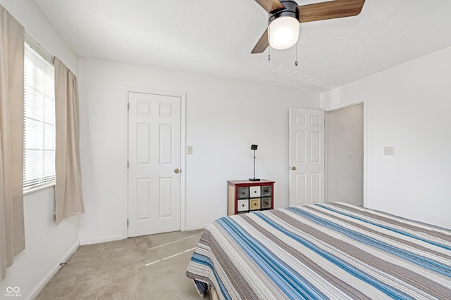 bedroom featuring a ceiling fan, light colored carpet, and baseboards