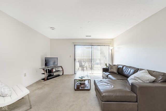 living area featuring visible vents, light carpet, and baseboards