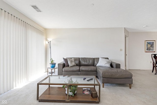 living area featuring visible vents, plenty of natural light, and carpet floors