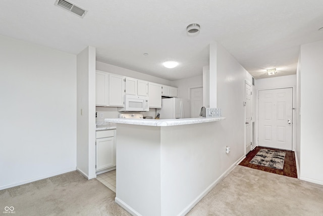 kitchen featuring white appliances, white cabinets, light colored carpet, and visible vents