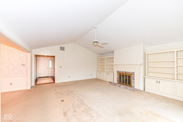 unfurnished living room with carpet, visible vents, a ceiling fan, a fireplace, and vaulted ceiling